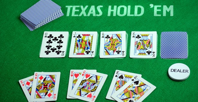 Ultimate Texas Hold'em community cards and dealer button on a casino table